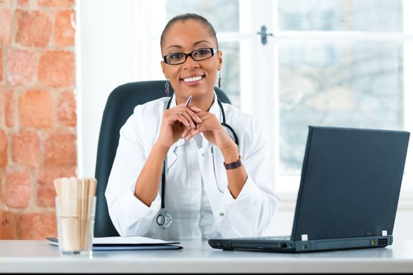 smiling nurse at a laptop