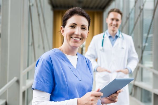 Smiling nurse and doctor in a brightly lit hospital wing
