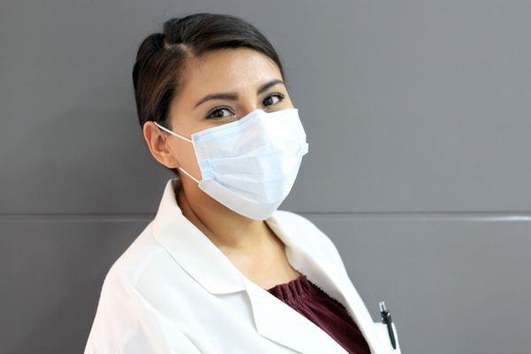 masked nurse looking into camera