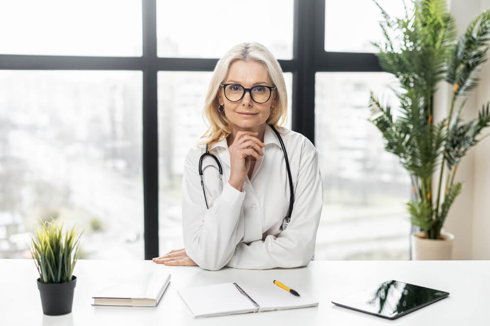 A nurse practitioner exhibiting her job satisfaction to the camera