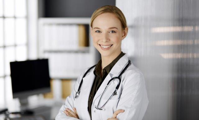 smiling nurse in lab coat with stethoscope