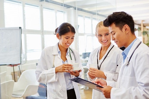 Two nurses confer with doctor