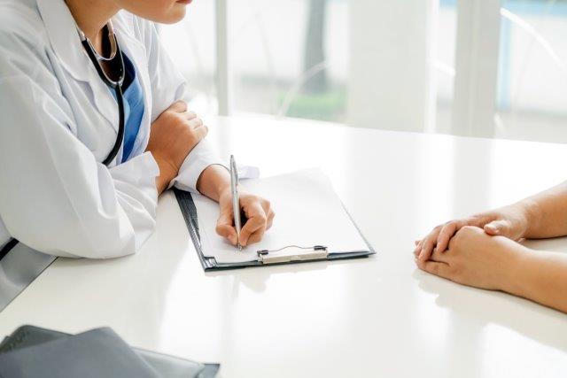 Nurse takes notes from a patient