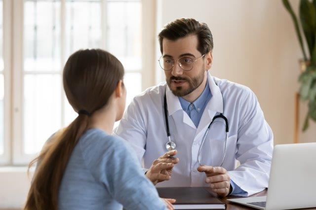 Nurse practitioner confers with patient