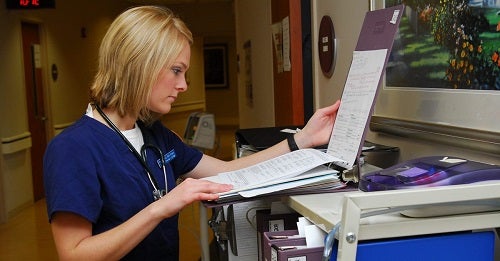 Nurse checking chart