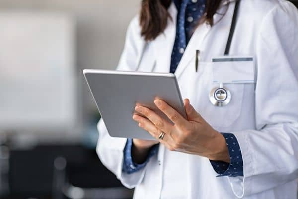 Female nurse practitioner making notes on a tablet device