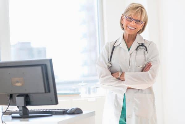Smiling mature female nurse practitioner in bright office setting