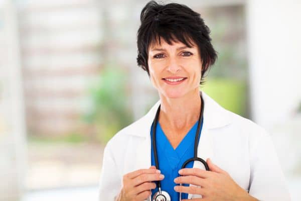 Mature female nurse practitioner wearing a stethoscope and white lab coat