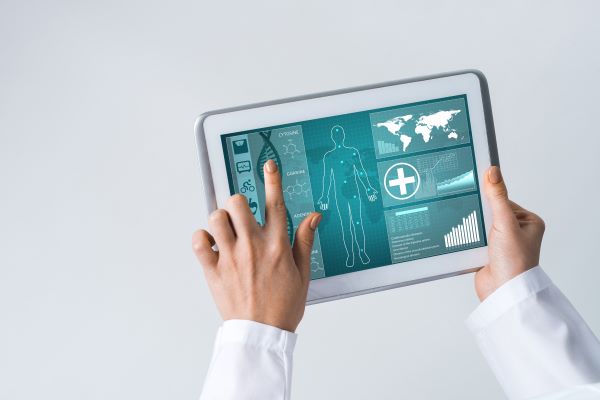 Close-up of a doctor's hands using a healthcare app on a tablet device