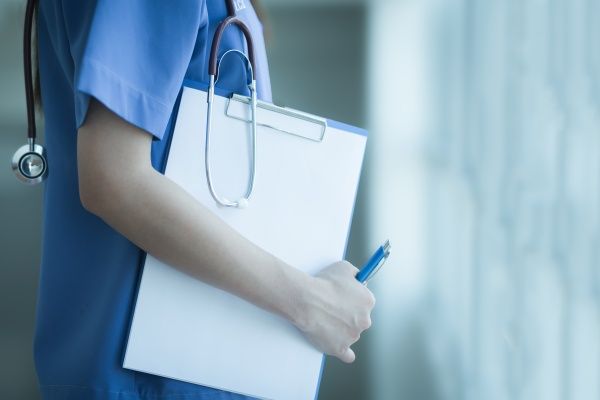 Registered nurse carrying a clipboard