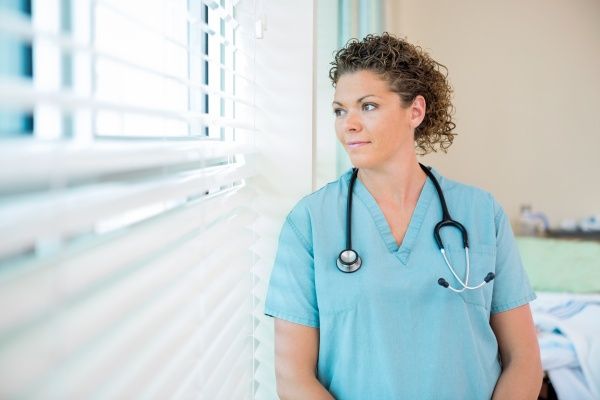 Registered nurse looking out of a hospital window