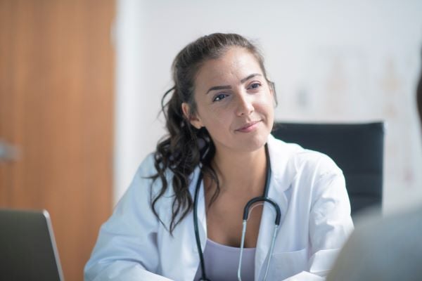 Female nurse practitioner talking to patient in her office